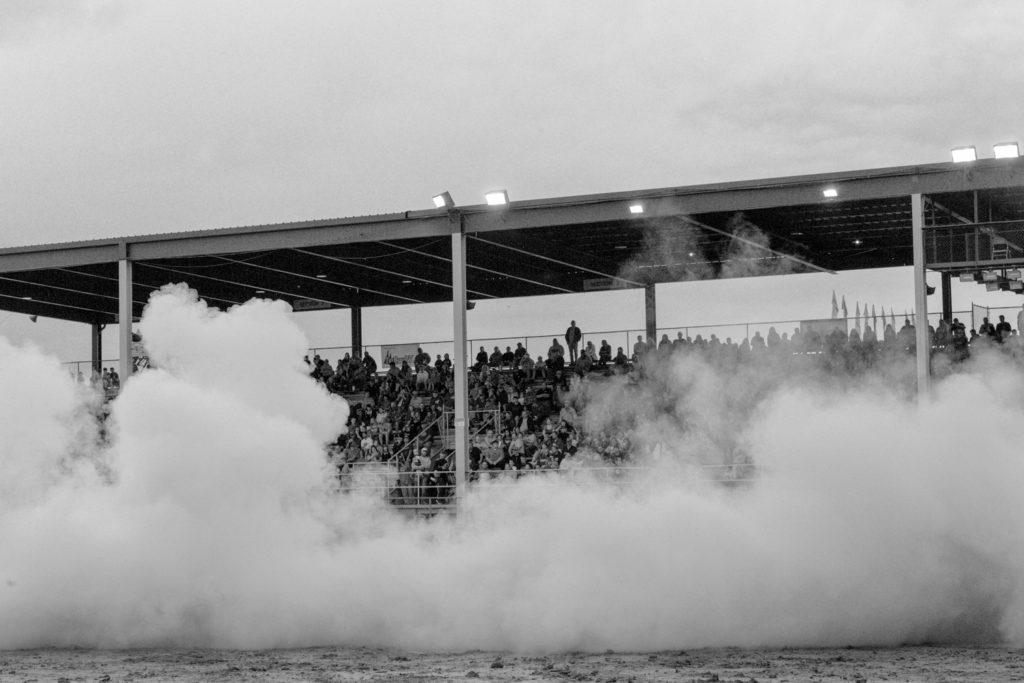 Midland, Michigan, USA. Midland County fair. The smoke produced by a car, during a bornout competition. In the background the spectators on the grandstands of the track.