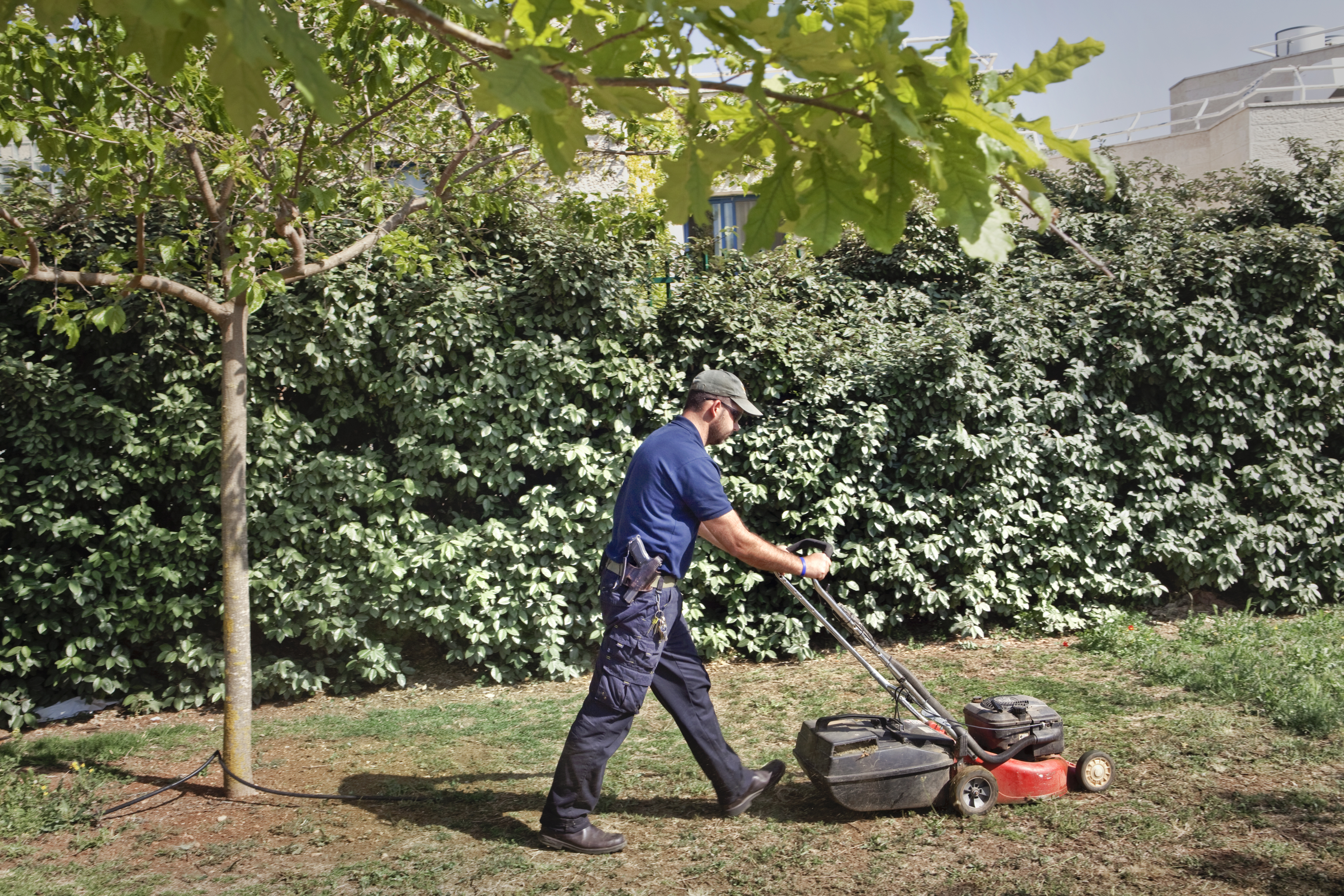 West Bank, 2013. Settlers. ### West Bank, 2013. Coloni. Settlement of Ofra, West Bank, 2013.
Maintenance of lawns on the “Fallen Soldiers
and Victims of Terrorism Remembrance Day”.
The use of weapons is widespread in
the settlements, even among civilians.
There is always at least one security guard
assigned to control who enters the settlements.