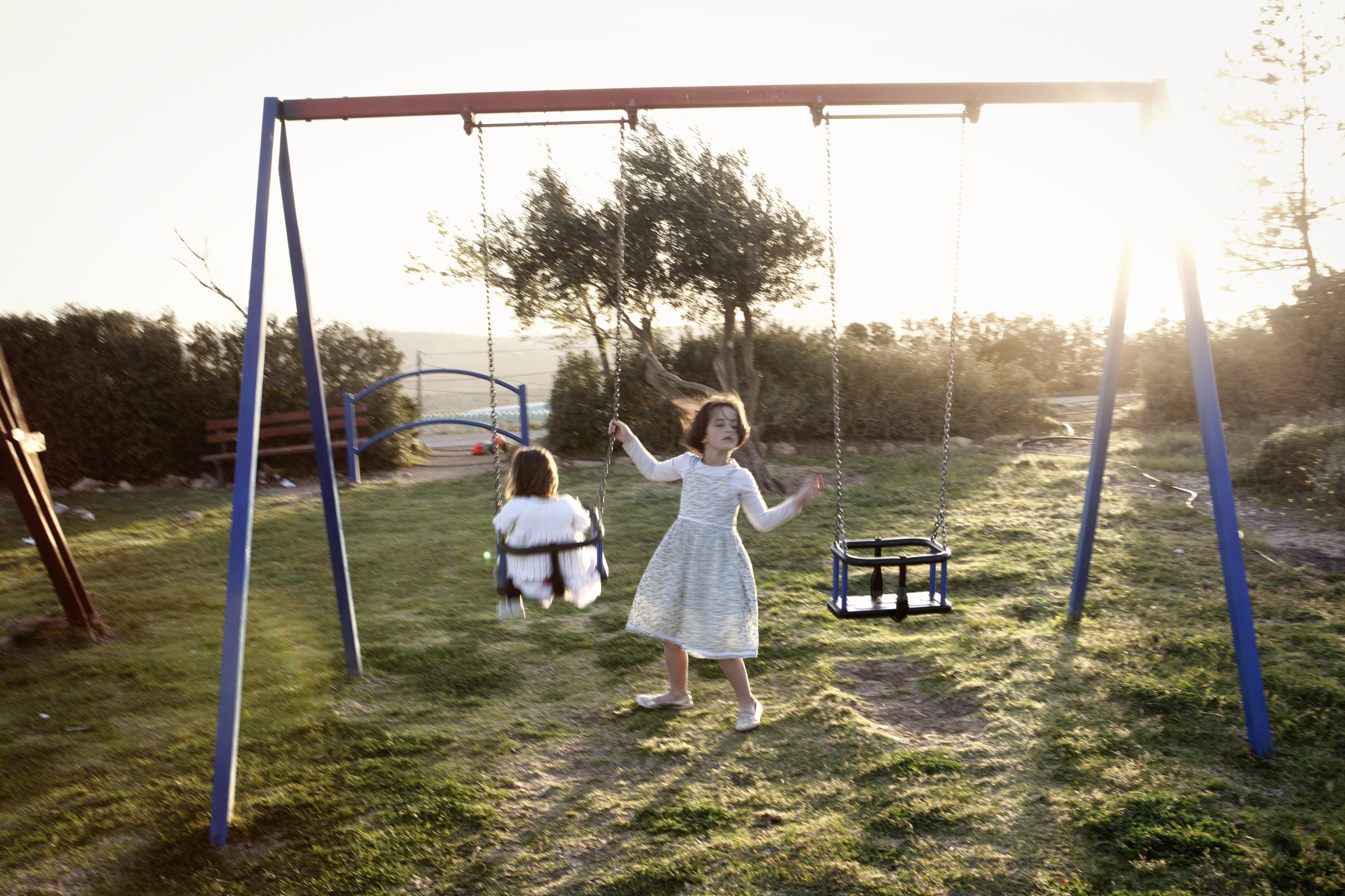 West Bank, 2013. Settlers. ### West Bank, 2013. Coloni. Outpost of Amona, West Bank, 2013. Two girls playing in the outpost of Amona. The outpost was established in 1995 on priavte Palestinian land and it was declared illegal under the Israeli law by the Israeli Supreme Court in 2006. Amona was partially dimantled in 2006. In 2014 the Israeli Supreme Court ordered to completely di-
smantle the outpost within two years. Amona has been demolished on February 2, 2017, with two years of delay. ### Avamposto di Amona, Cisgiordania, 2013. Il parco giochi.
L’avamposto è stato fondato nel 1995 su terra privata palestinese e fu dichiarato illegale dalla Corte Suprema secondo la legge israeliana nel 2006. Amona fu parzialmente smantellato nel 2006. Nel 2014 la Corte Suprema israeliana ordinò di smantellare completamente l’avamposto entro due anni. Il 2 febbraio 2017, con un ulteriore ritardo di due anni, tutte le case di Amona sono state demolite.