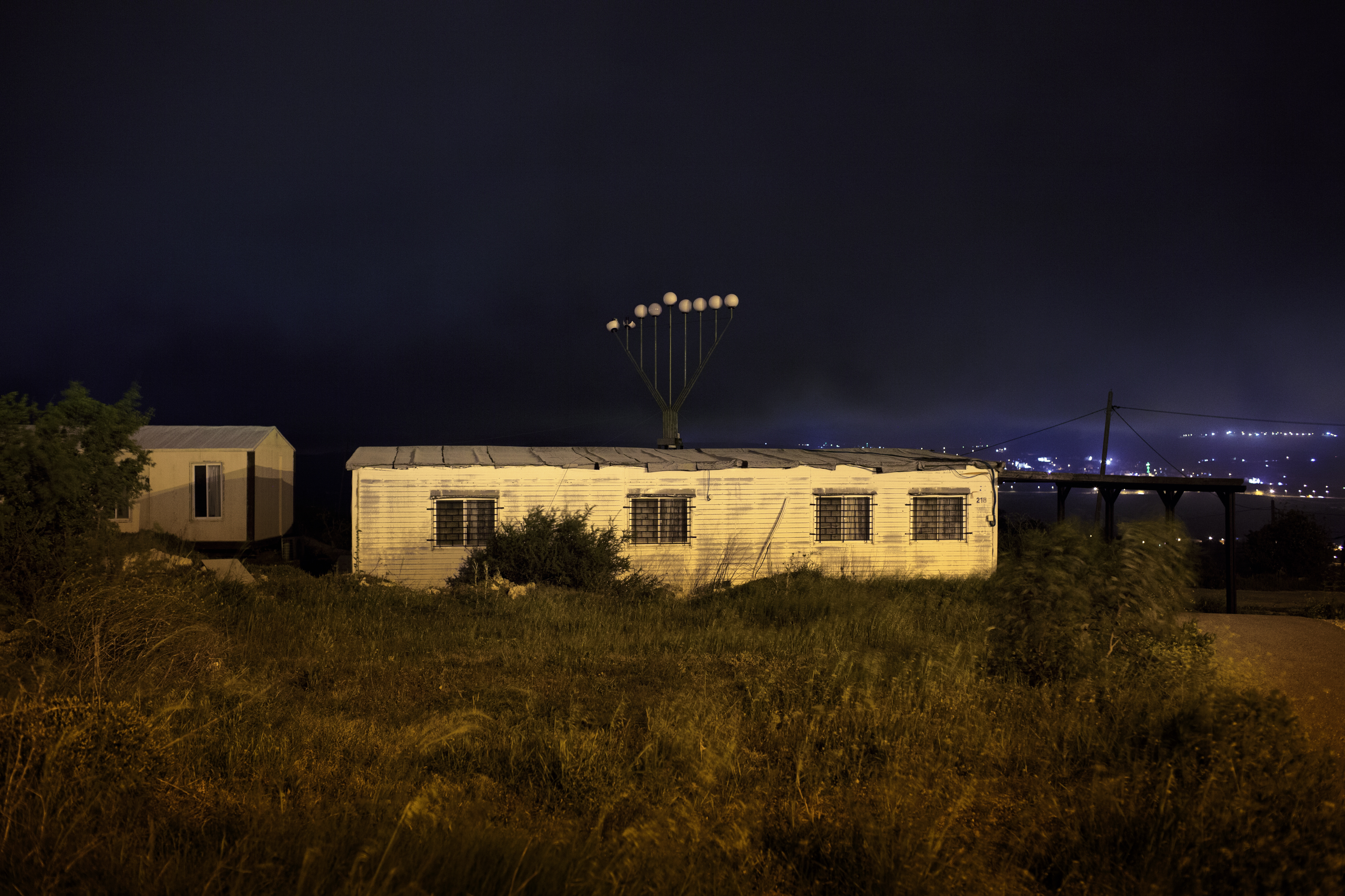 West Bank, 2013. Settlers. ### West Bank, 2013. Coloni. Outpost of Jabel Artis, West Bank, 2013.
The synagogue. Jabel Artis is an outpost created by
the expansion of the settlement of Bet El. All twenty
of the prefabricated homes placed on the hill in 2001
lie entirely on private Palestinian land, next to what
is considered the place of Jacob’s dream described
in the Bible. The outpost is protected day and night
by a sophisticated system of video surveillance.