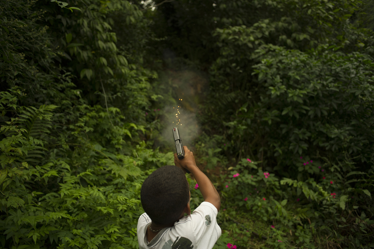 A 11 years old boy, member of an armed criminal faction in São Paulo Brazil, training shooting with an 9mm automatic hand gun.