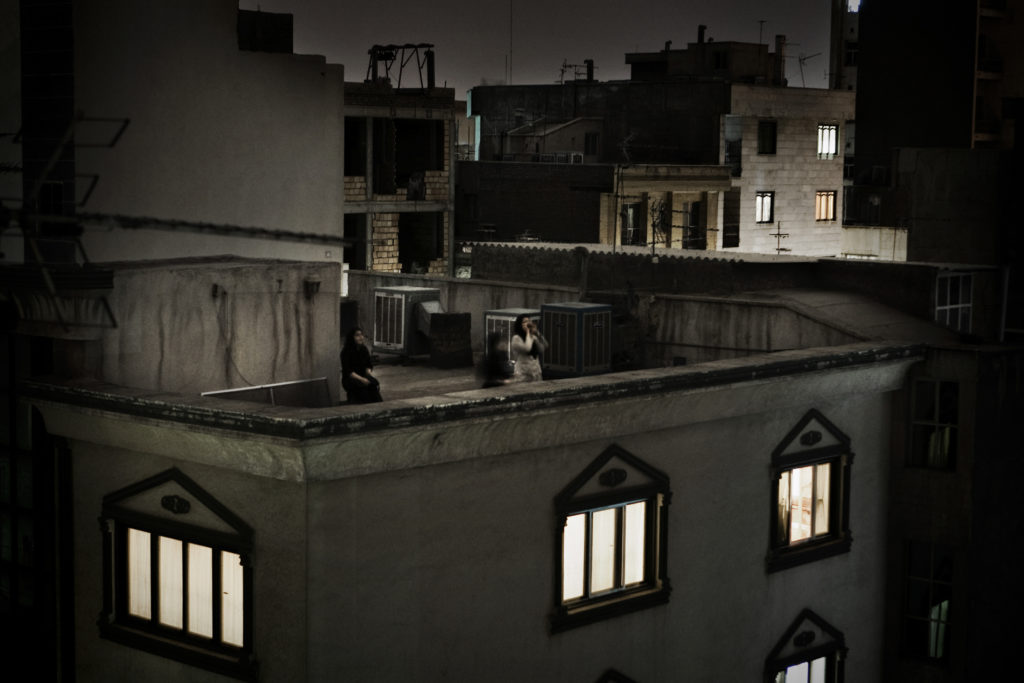 Women shout against the regime from the rooftop of their house. ### Donne gridano il proprio dissenso contro il regime dal tetto della propria abitazione.