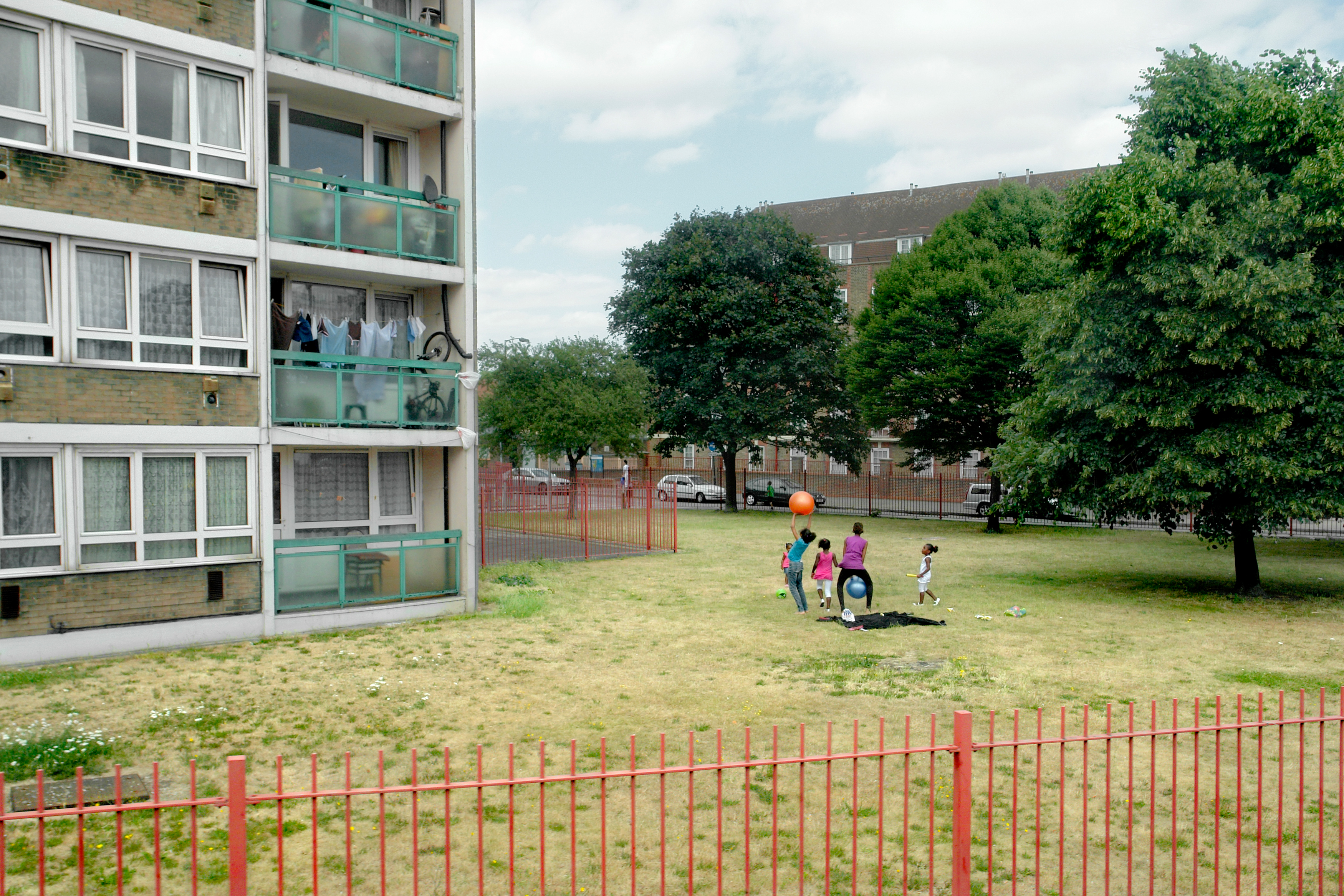 Children play in the gardens of a housing block along the route of Bus 188 between Russell Square and North Greenwich.[This image was photographed through the window of one of London's double decker busses and is part of 'Last Stop', a photo project now published as a book, which aims to document the city, its movements and migrations, its landscape and architecture, its diversity and energy.]