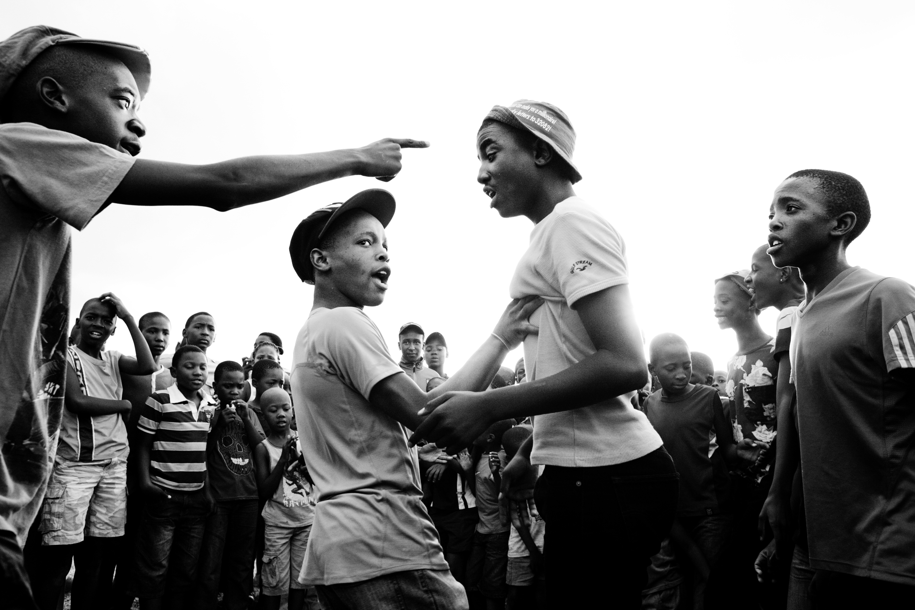 Sibusiso Mgoduka, 16 (far right), watches his friend battle another Izikhothane group in a park near their home in Katlehong, near Johannesburg. Izikhothane is a new subculture among South African youth, in which groups of teen-age boys battle each other in dissing, dancing, and who has the best designer clothing. “Izikhothane is like being a famous guy in Katlehong,” says Mgoduka. “It’s about bragging.”