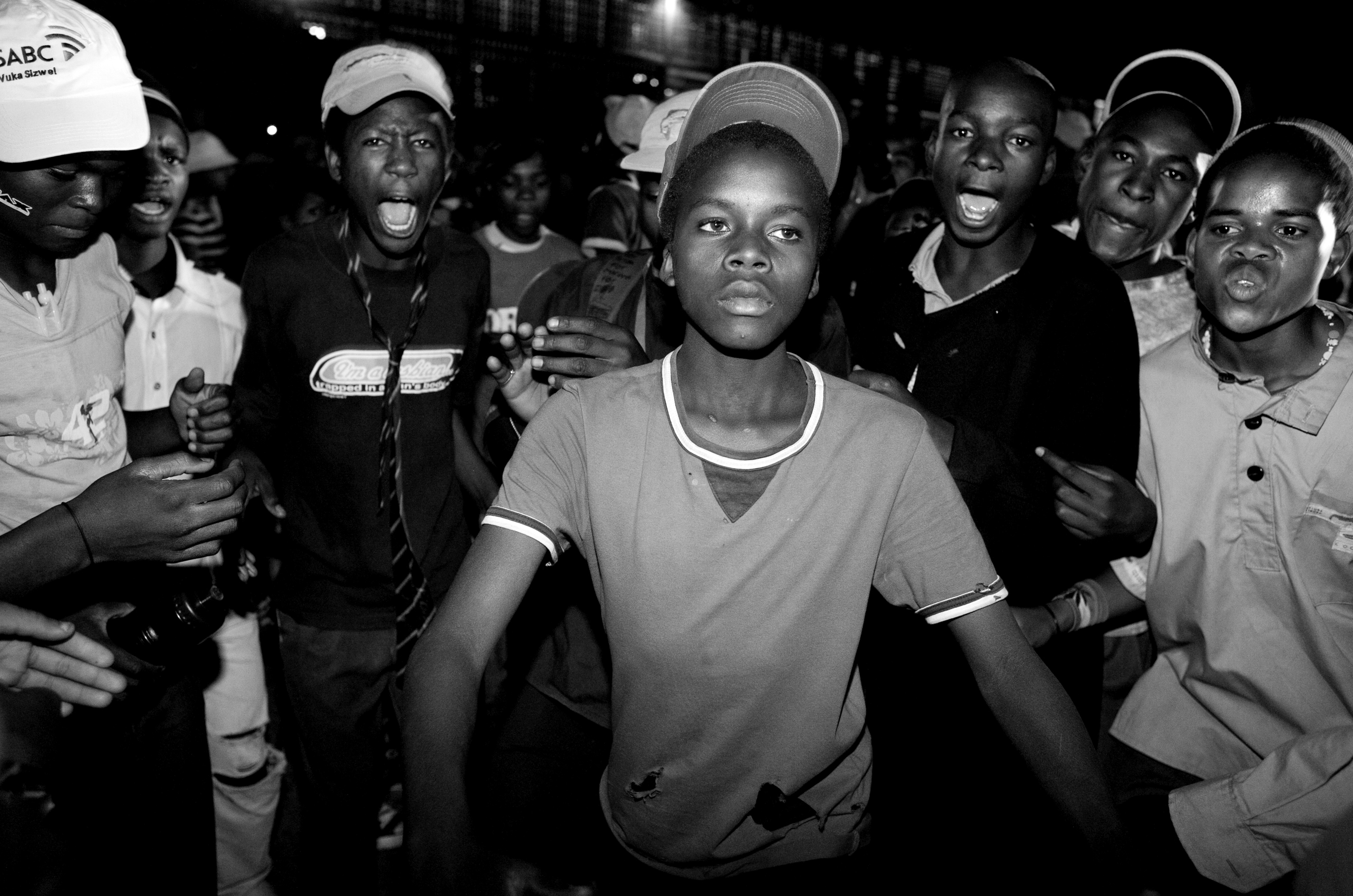 Kwaito Culture - Young kids dance to Kwaito music during the Soweto music festival in Johannesburg, South Africa. 2007 Kwaito, the musical genre emerging out of the South African townships at the end of apartheid, has traveled from homes, into the clubs, and out onto the streets, evolving into an urban culture that has swept the countries youth into communalized rebellion and self-expression through music and dance. Not unlike early blues and hip-hop in the US, Kwaito tells stories - of life impoverished, but also of being young and sexual and free. This work looks at Kwaito culture in the South African townships of Johannesburg.