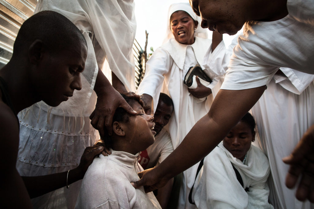 The exorcism of a 13 years old new mother, crying and sceraming while being held by five exorcist and her older husband. (Madagascar - Toliara city - Toby Betela)