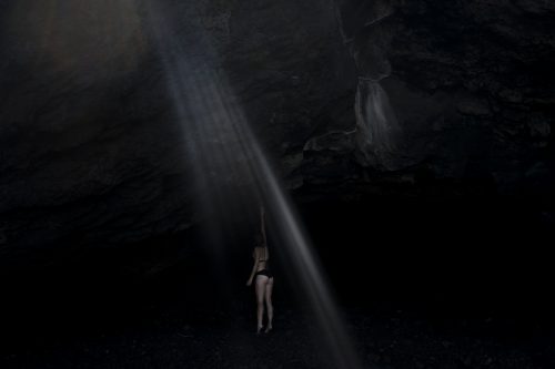 Writer Laurence Cornet, on Stromboli island for a reporting trip, reaches for a rock at “Aeolus’ Cave”, a small beach on Stromboli Island. Aeolus, the Greek god of the winds, was thought to have moved his headquarters from a nearby island to Stromboli in order to better control and distribute the winds in the Mediterranean sea. Stromboli, Eolie Islands, Italy.