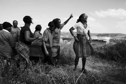 Thabsile Brightness Sishi, 25 (right), leads the funeral procession for her aunt Thembi Veze, along with her brother, Bongumenzi Knowledge Sishi, 15. Thabsile and Bongumenzi have been living with their aunt and her three children in the Richmond Farm Transit Camp near Durban since 2009.  “In the camp, I can’t say it’s nice to stay here– there’s no park, nowhere to play soccer, nowhere to rest,” says Bongumenzi. “It’s too dangerous. There’s no security. We are waiting for moving – they are still building the RDPs. They said we would be here two years.”